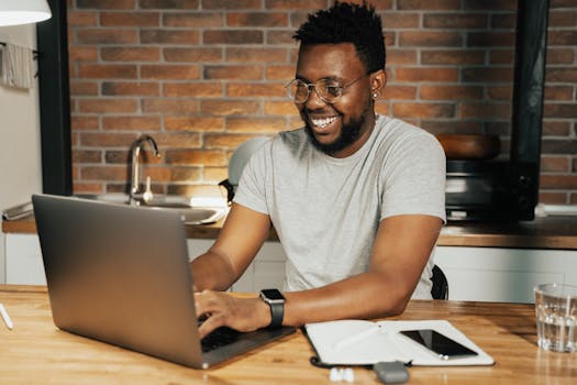 freelancer smiling while working on a laptop